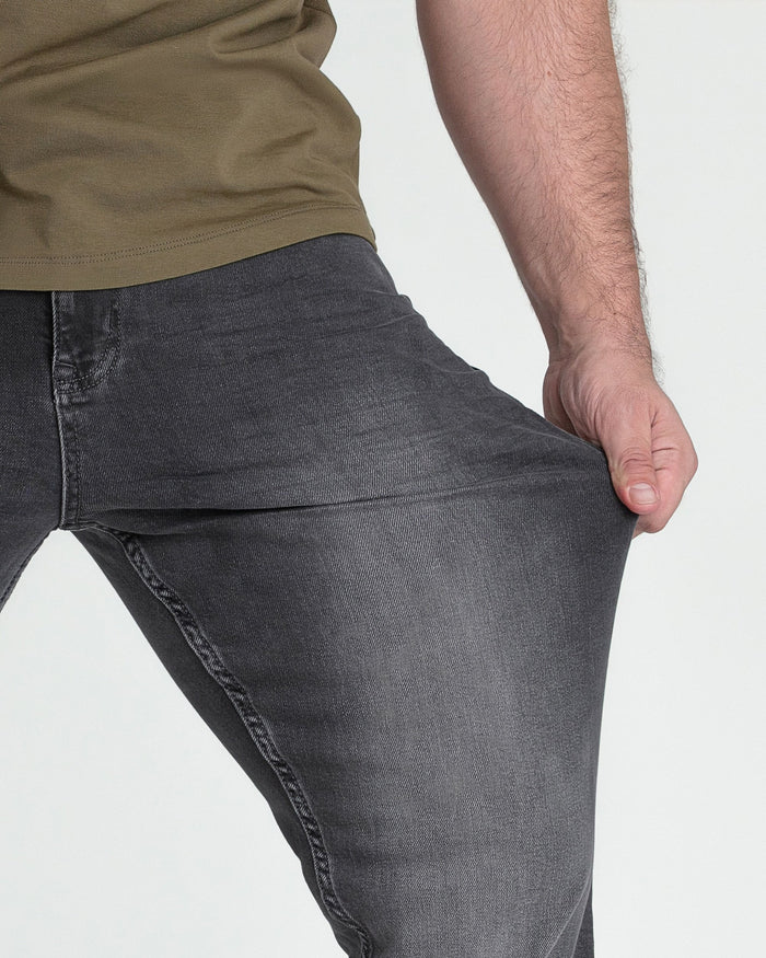 Grey bootcut jeans with visible stitching and seaming detail on male model wearing tan shirt.