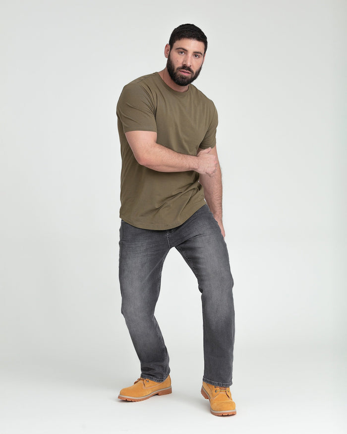 Man wearing olive t-shirt and grey bootcut jeans with tan work boots.