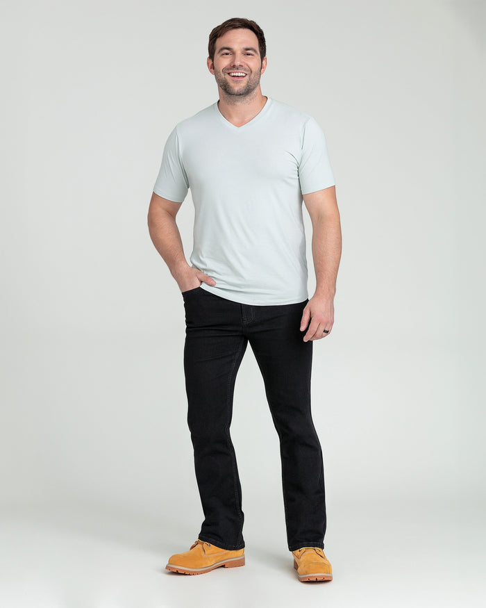 Man wearing light gray v-neck t-shirt and black bootcut jeans with tan work boots.