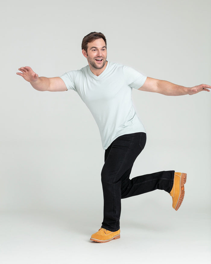 Black bootcut jeans with a slightly flared leg, shown on a model wearing a white t-shirt.