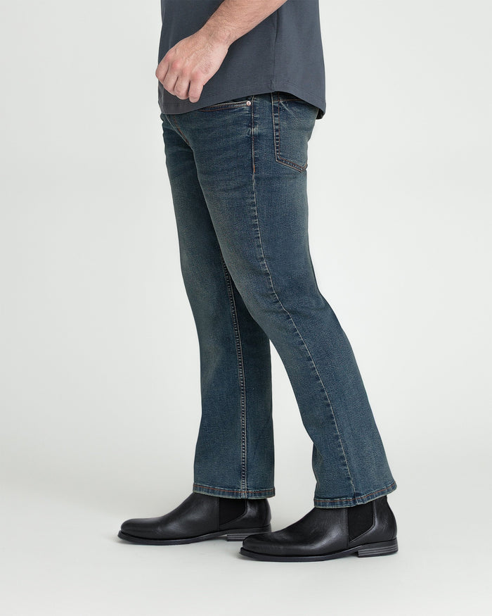 Tinted bootcut jeans in dark blue denim worn with black Chelsea boots.