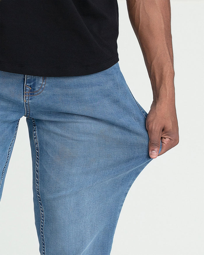 Light indigo bootcut jeans with visible stitching, shown on model wearing black t-shirt.