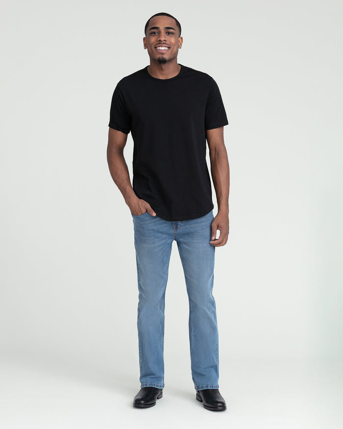 Light indigo bootcut jeans styled with a black crewneck t-shirt and black shoes.