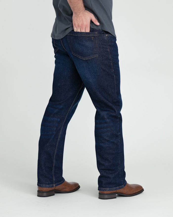 Dark blue bootcut jeans with visible stitching, shown on a model wearing brown boots.