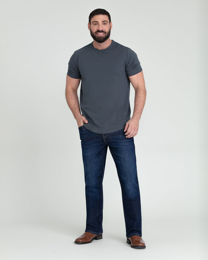 Man wearing dark blue bootcut jeans with a charcoal t-shirt and brown boots.
