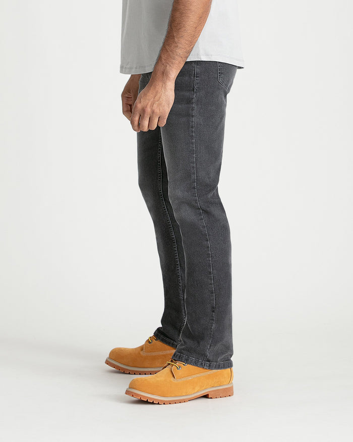 Grey bootcut jeans with visible stitching and leg opening, styled with tan work boots.