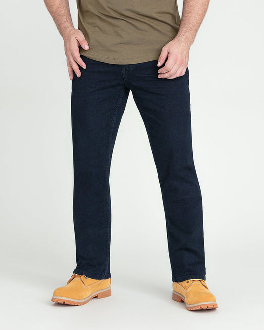 Man wearing deep blue bootcut jeans with tan shirt and tan work boots.