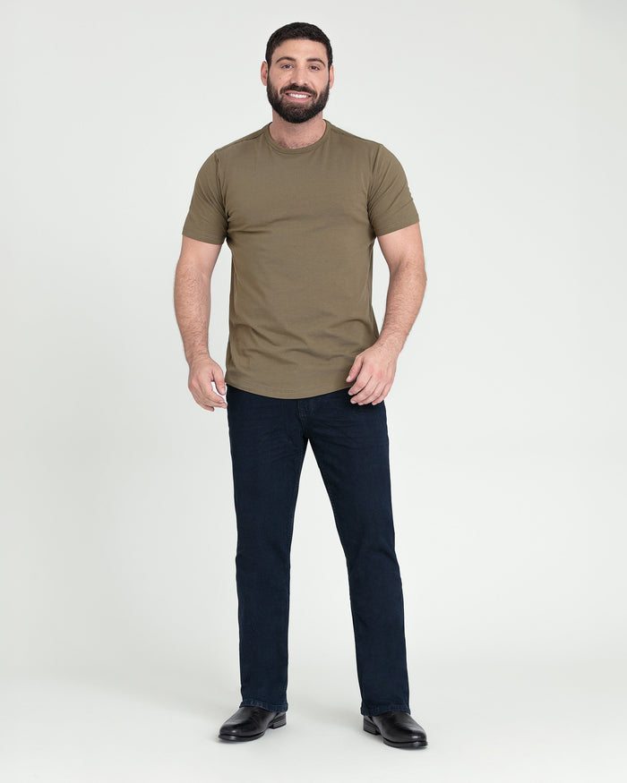 Man wearing tan short-sleeve t-shirt and dark blue bootcut jeans with black shoes.