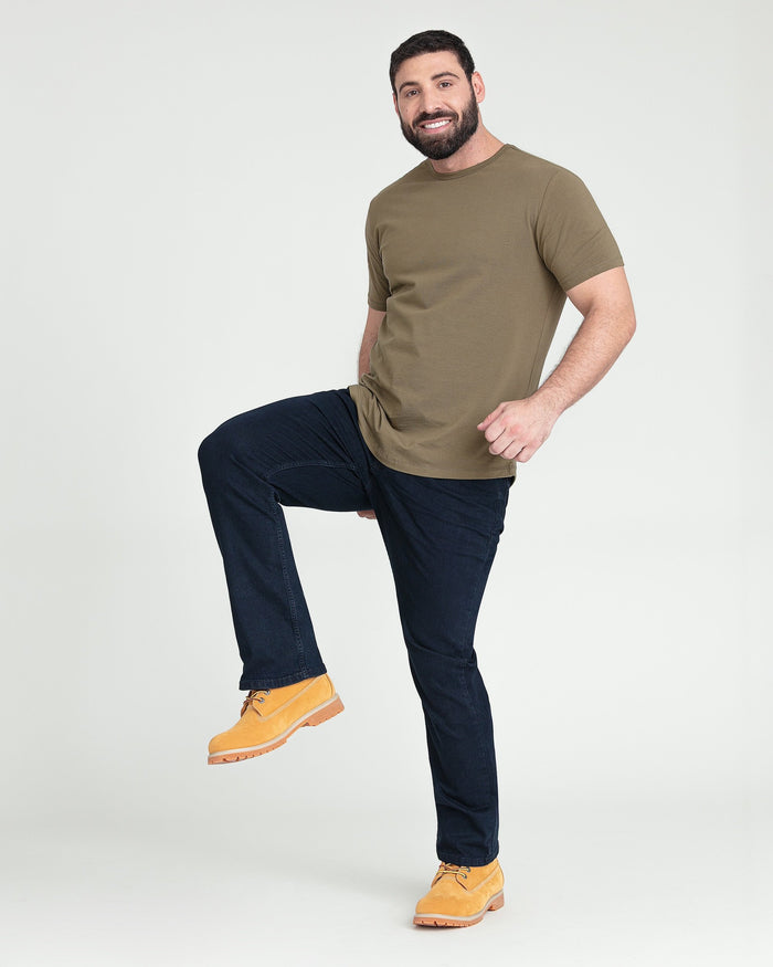 Man wearing olive t-shirt and dark blue bootcut jeans with yellow work boots.