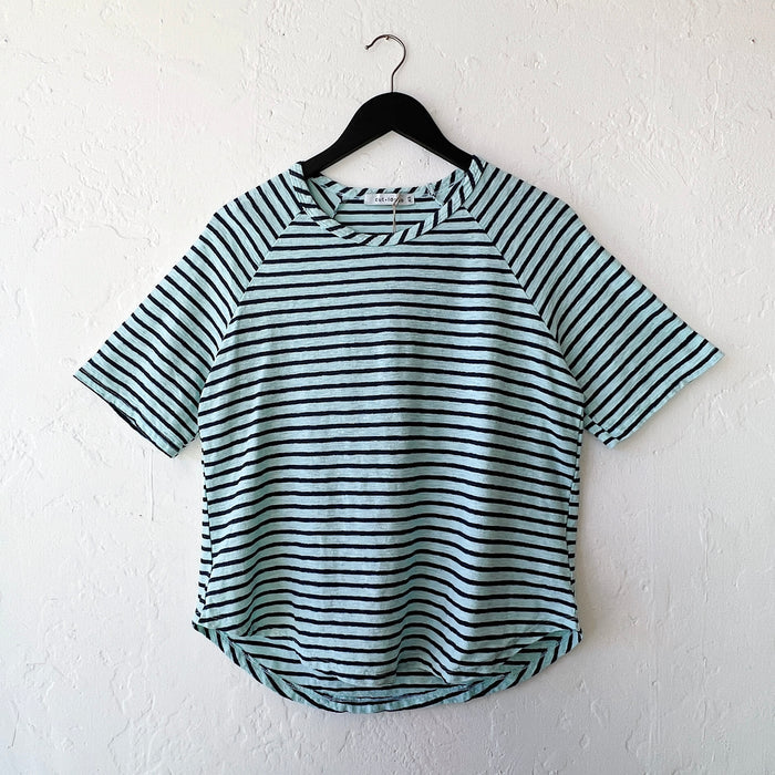 Striped shirt on a hanger against a white wall