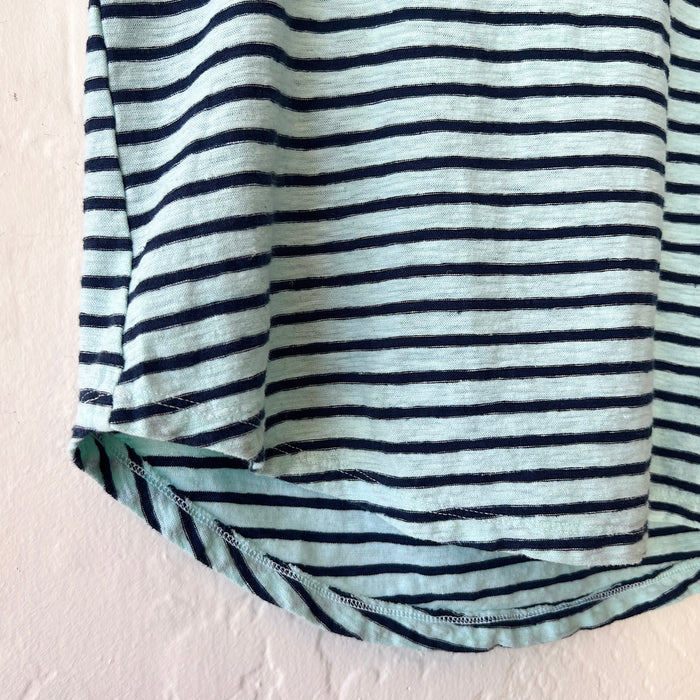Close-up of striped shirt with blue and black horizontal stripes on a light pink background