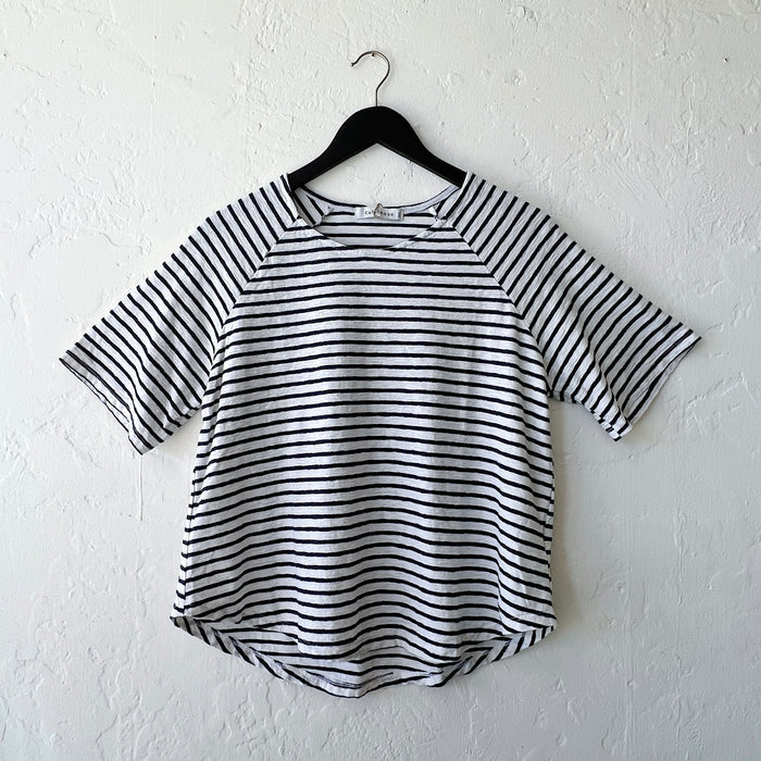Navy and white striped shirt on a hanger against a white wall