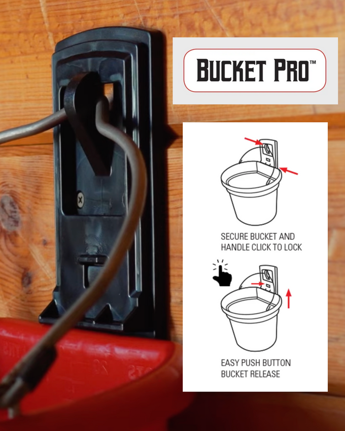 The Bucket Pro bucket holder mounted on a wooden barn stall wall, securely holding a red flat-back bucket. The Bucket Pro logo is visible, along with a black and white instructional diagram demonstrating how to use the holder.