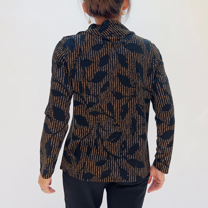 Person wearing a patterned shirt with long sleeves on a white background, shot from behind.