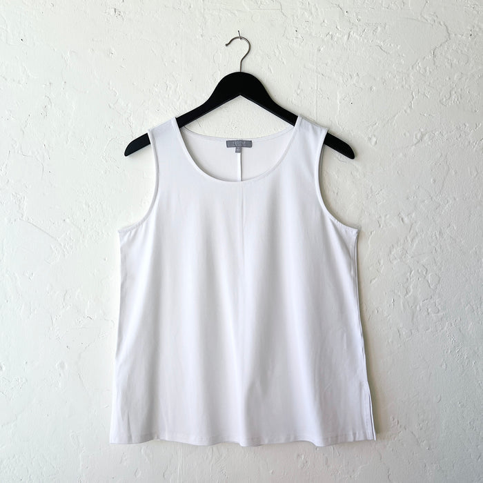 White tank top on a hanger against a white wall