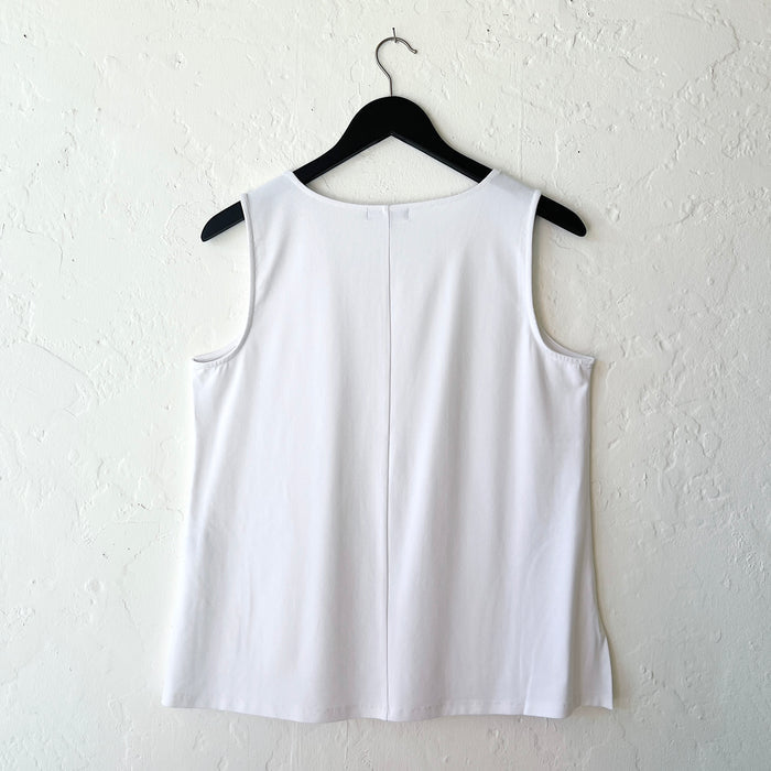 White sleeveless top on a hanger against a white background
