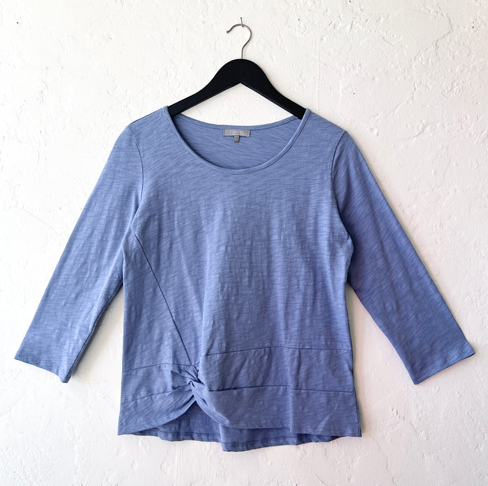 Blue long-sleeve top on a hanger against a white background