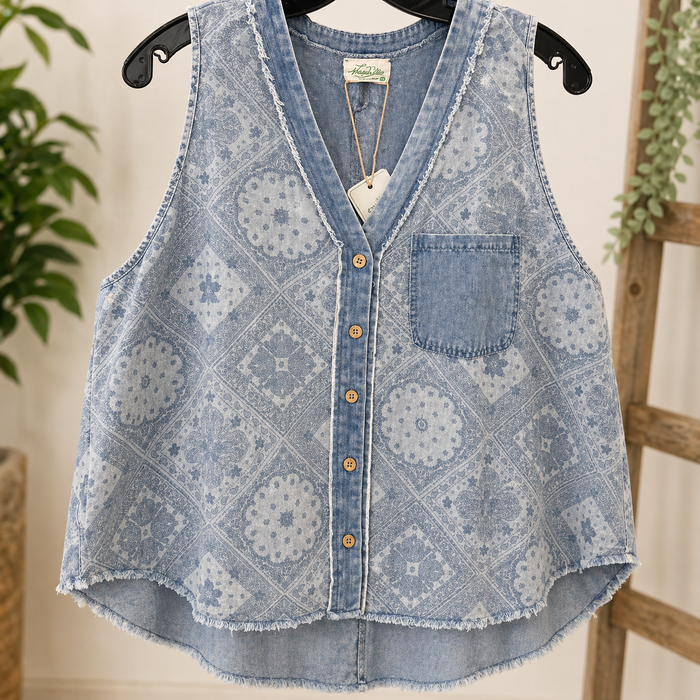 Denim tank with floral pattern on a hanger against a neutral background
