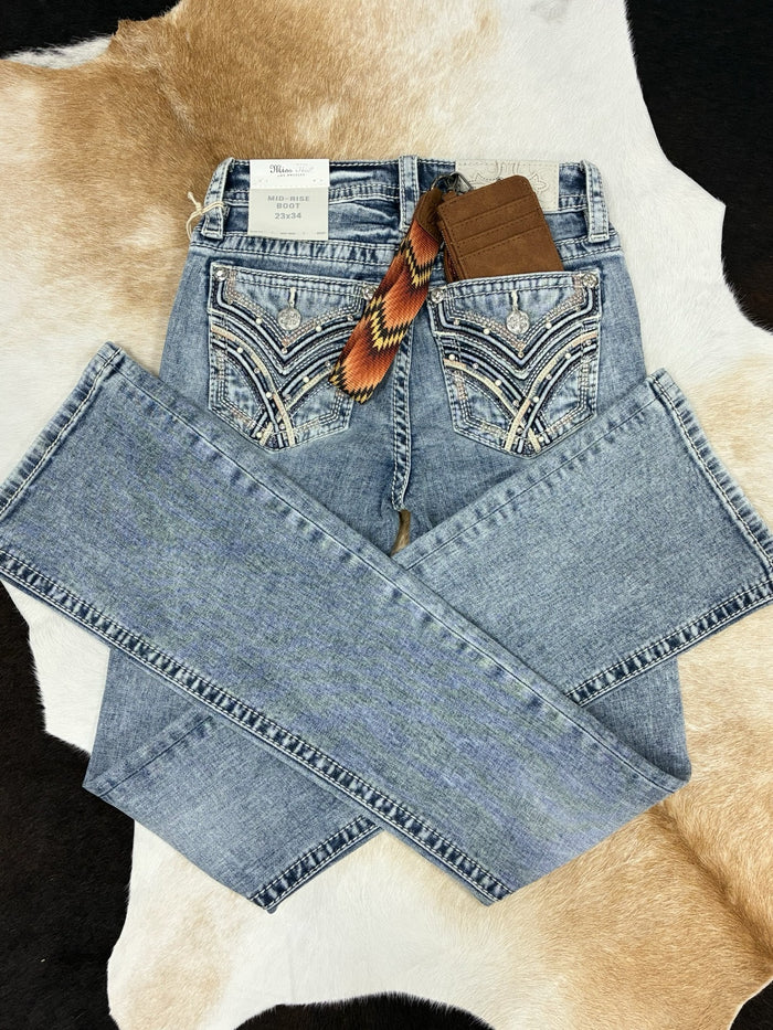 Pair of blue jeans with a patterned tag on a cowhide rug