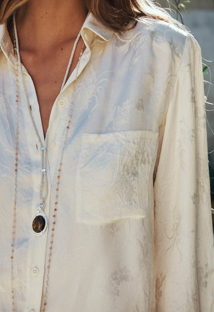 Close-up of Dubois Shirt chest pocket and floral jacquard Naia acetate fabric in pearl with button placket detail