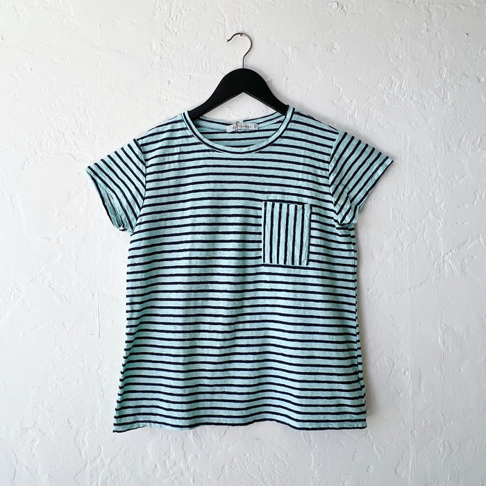 Striped t-shirt with a pocket on a hanger against a white wall