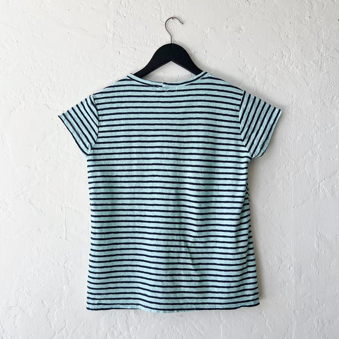 Striped t-shirt on a hanger against a white wall, viewed from the back.
