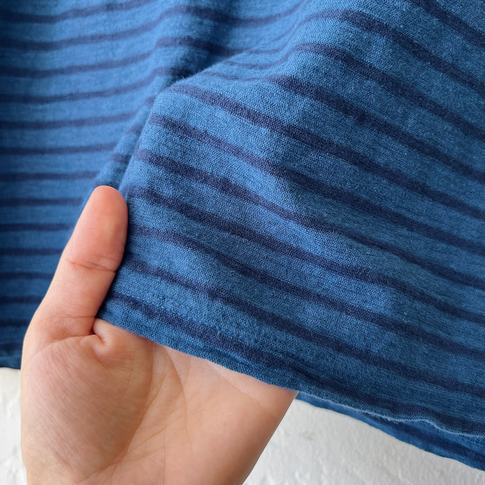 Close-up of a hand holding blue striped fabric