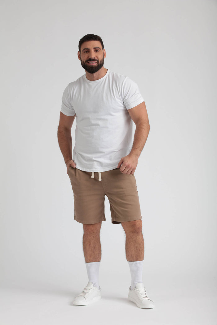 Man wearing light khaki athletic shorts with drawstring waist and white t-shirt.