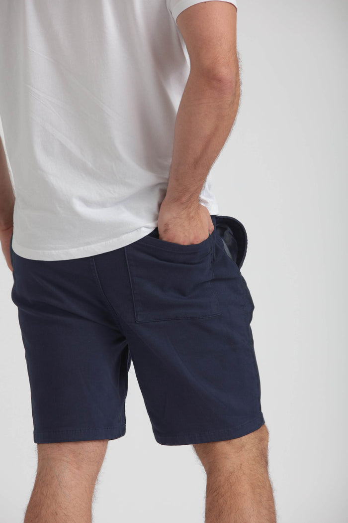 Man wearing navy athletic shorts with side pocket, paired with white t-shirt.