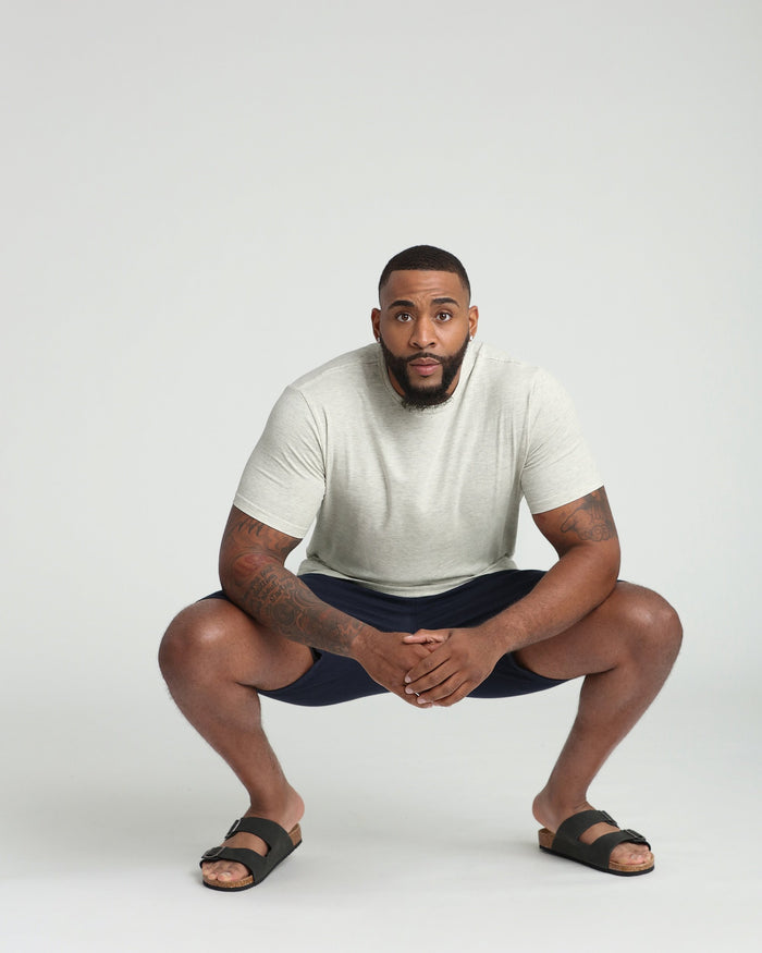 Navy athletic fit shorts with elastic waistband, worn with light gray t-shirt and black sandals.