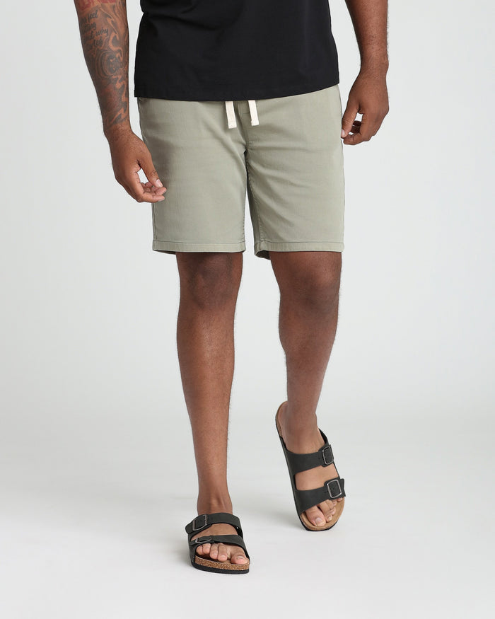 Light green athletic fit shorts with drawstring waist and rolled cuffs, modeled with black t-shirt.
