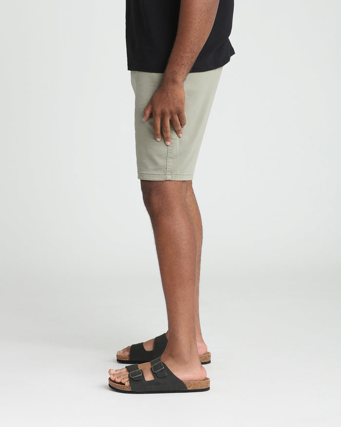 Light green athletic fit shorts on a model wearing a black shirt and black sandals.