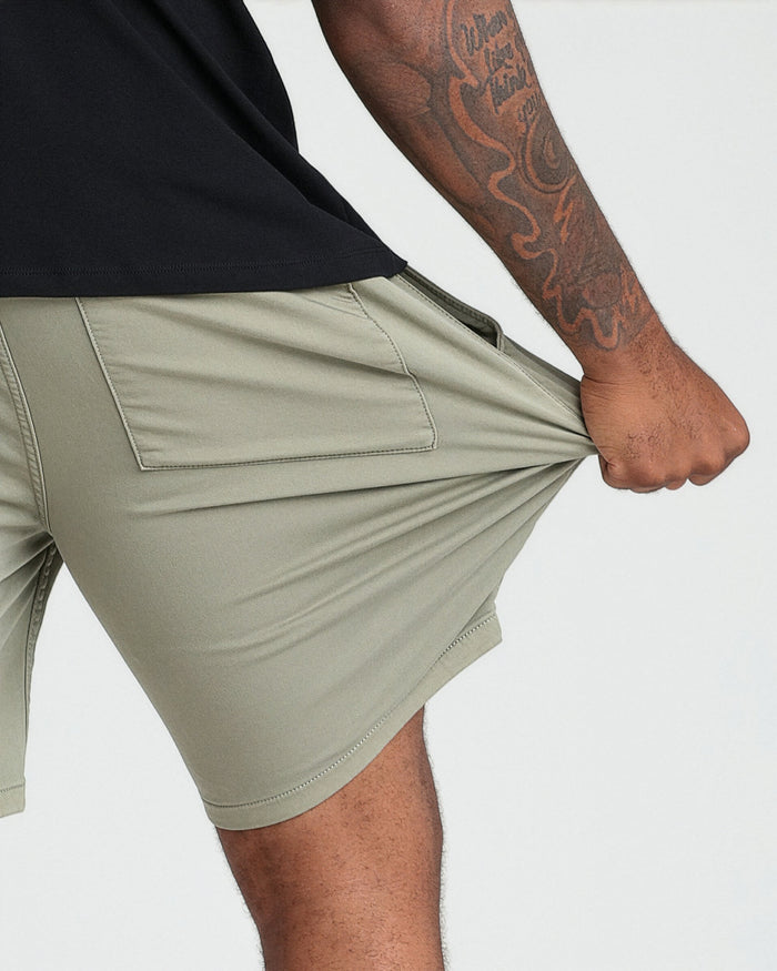 Light green athletic shorts with back pocket, worn by male model with black shirt.