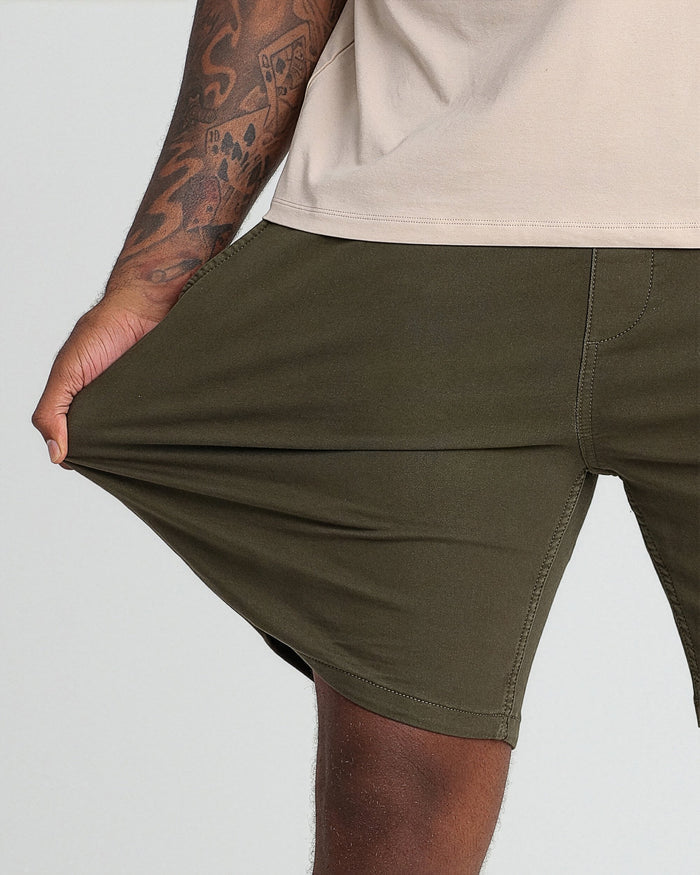 Soldier olive athletic fit shorts with side seam pockets and stitched details, worn with a cream t-shirt.