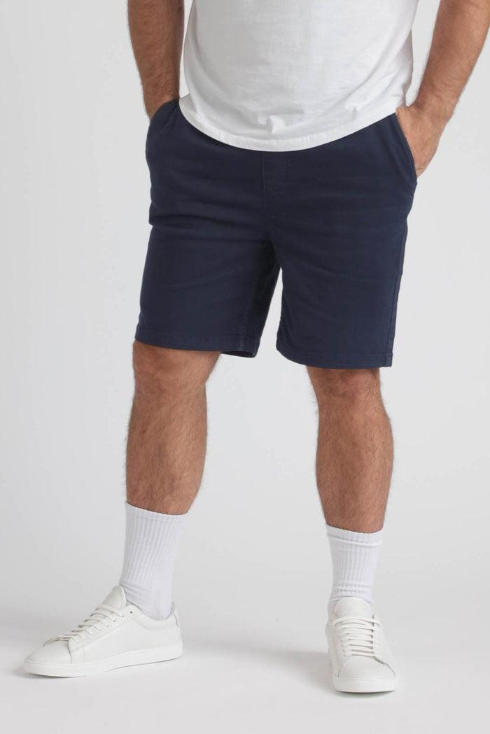 Man wearing navy athletic shorts with white socks and white sneakers.