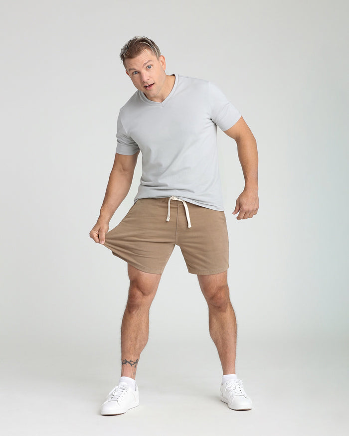 Man wearing light gray t-shirt and dark khaki slim fit shorts with drawstring waistband.