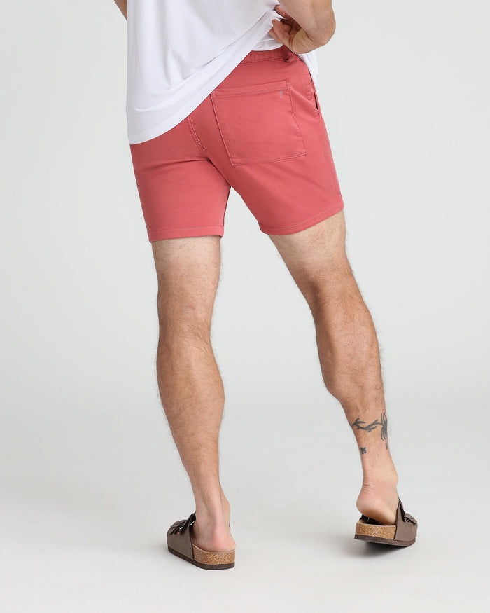 Man wearing nantucket red slim fit shorts with back pocket detail and white t-shirt.