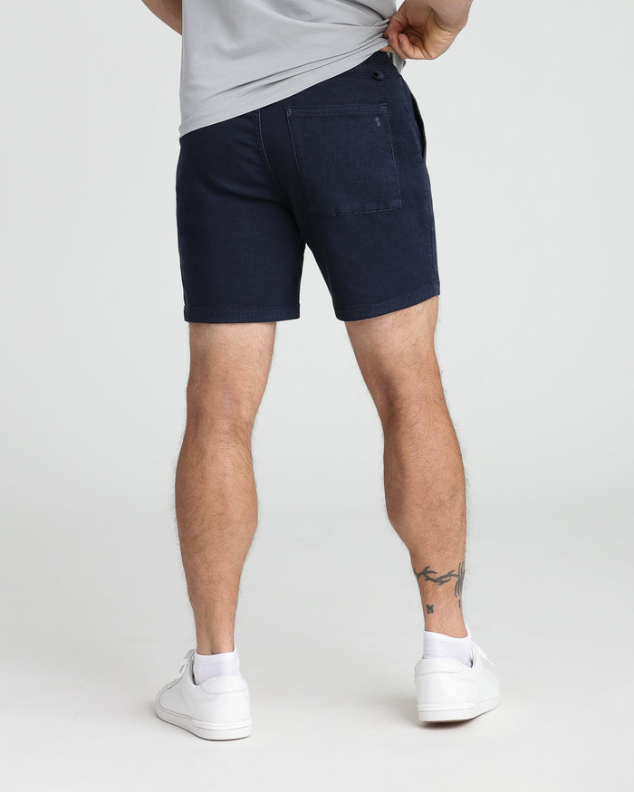 Navy slim fit shorts with back pocket, worn with white t-shirt and white sneakers.