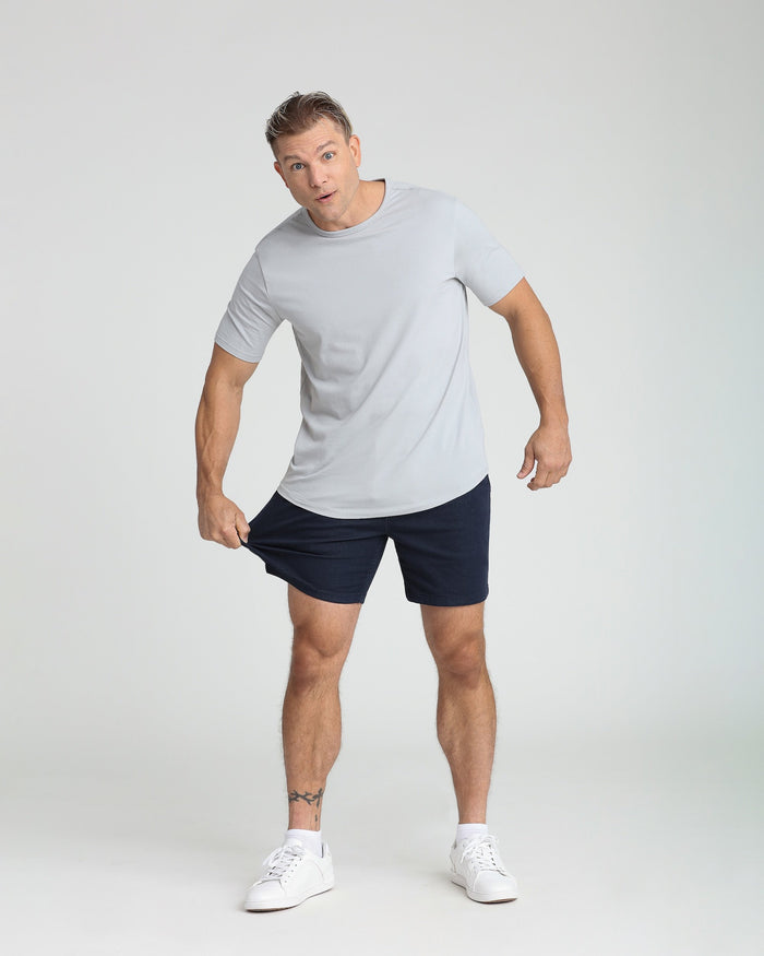 Man wearing navy slim fit shorts with light gray t-shirt and white sneakers.