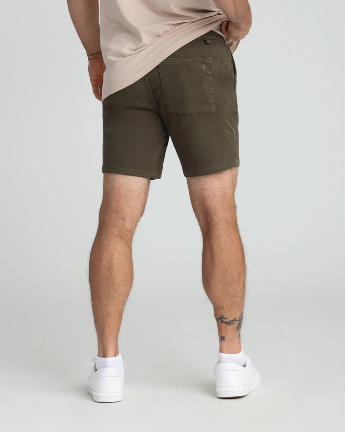 Soldier olive slim fit shorts worn with cream t-shirt and white sneakers, back view.