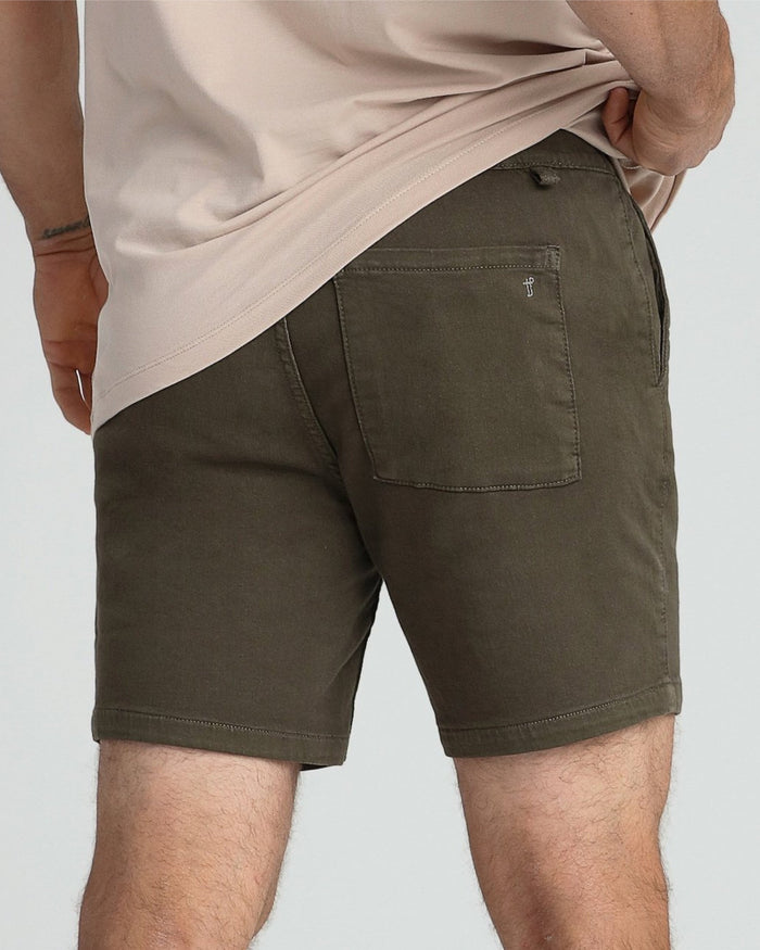 Soldier olive slim fit shorts with back pocket, worn with cream colored shirt.