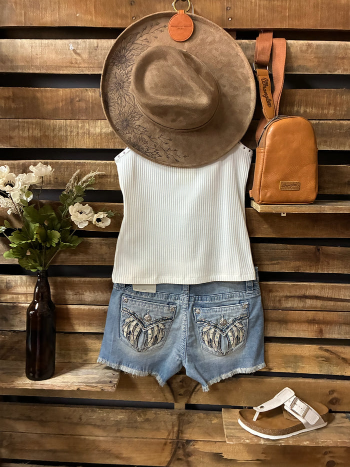Outfit with white tank top, blue shorts, brown hat, and tan backpack on a wooden surface.
