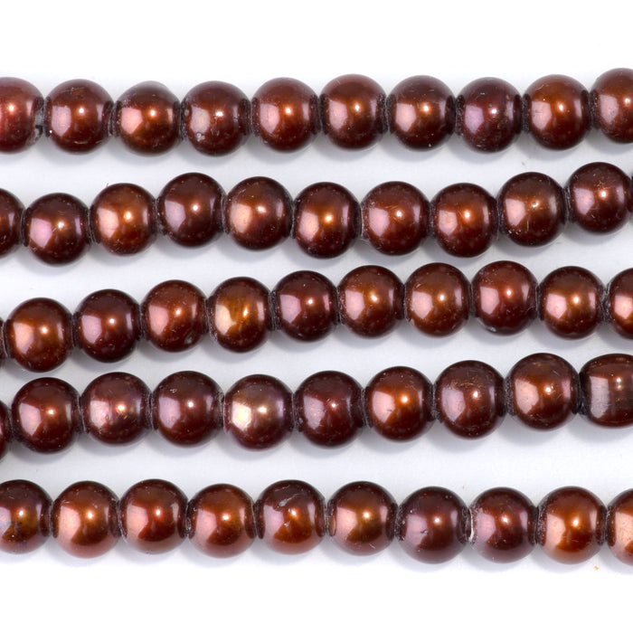 This is a Dakota Stones 6-7mm Freshwater Pearl Red Brown Gold Gemstone strand of round beads in 8 inch strand.