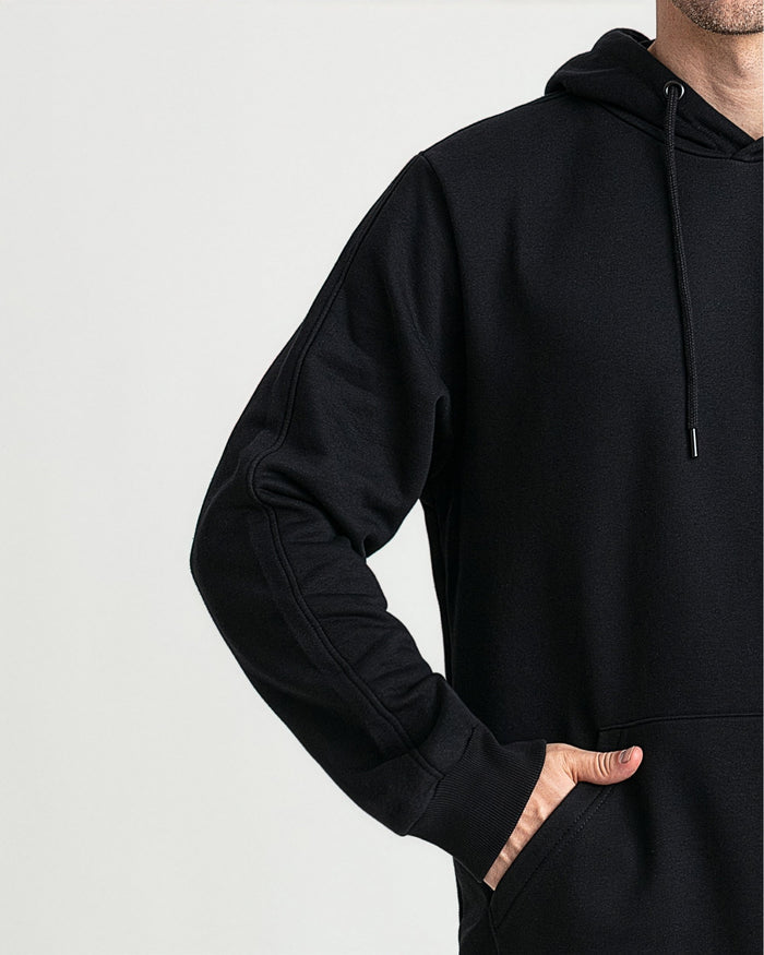 Black hoodie with drawstring, ribbed cuffs and kangaroo pocket, worn by male model.