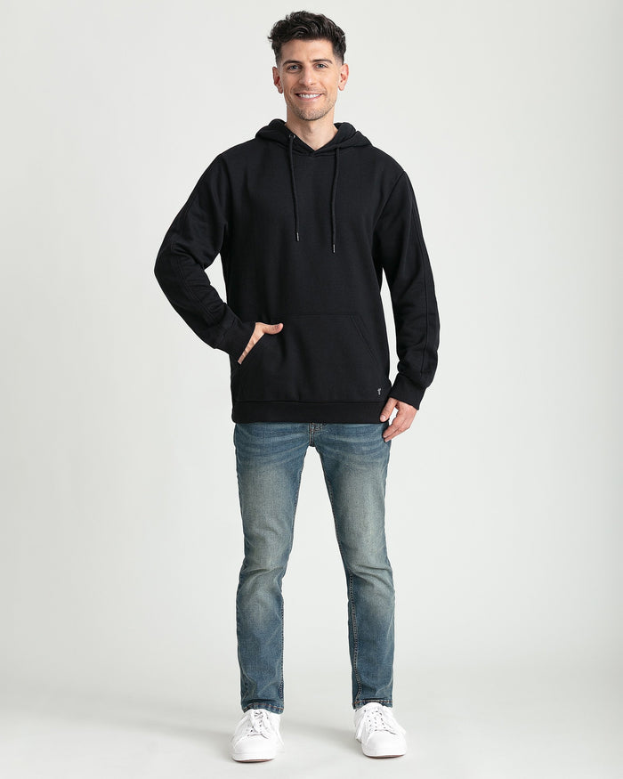 Black pullover hoodie with drawstring hood, kangaroo pocket, and ribbed cuffs worn by male model.