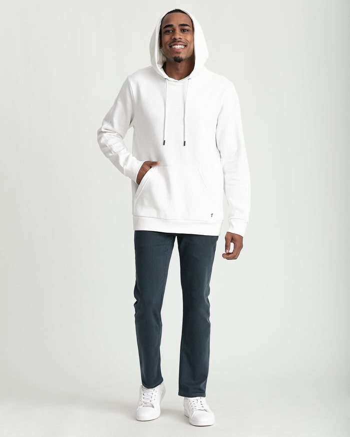 Man wearing cream-colored hoodie with drawstring, front kangaroo pocket, and long sleeves.