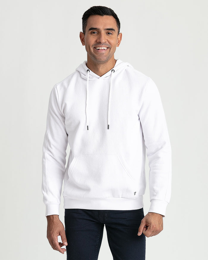 White pullover hoodie with drawstring, kangaroo pocket, and ribbed cuffs on model wearing dark jeans.
