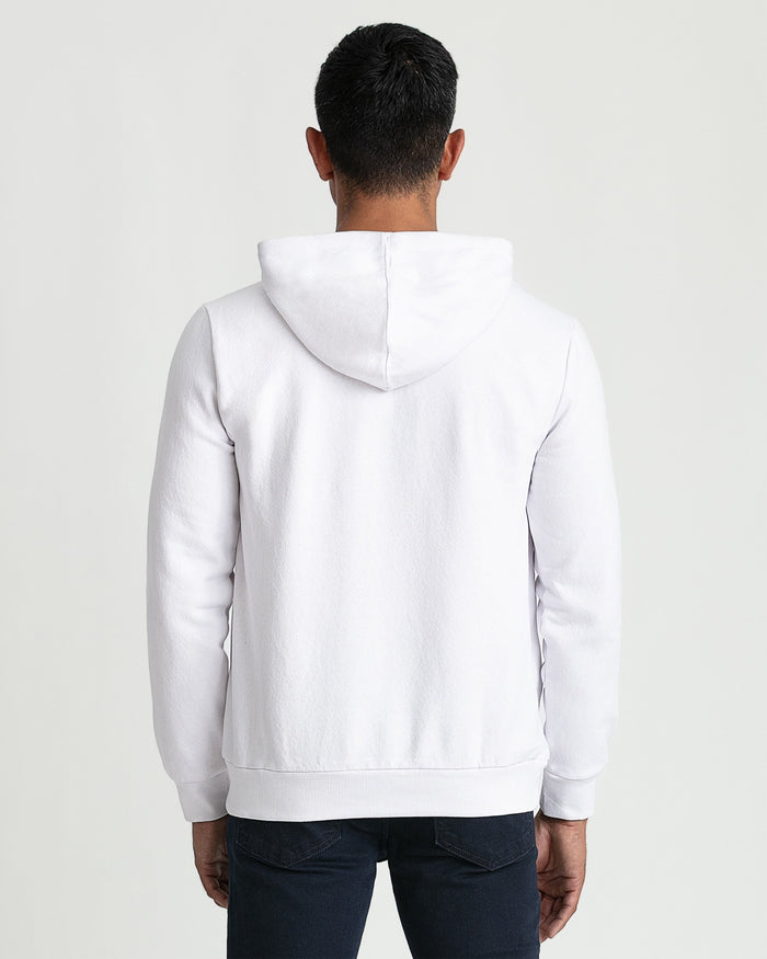 White pullover hoodie with kangaroo pocket and drawstring, shown from back on male model wearing dark jeans.