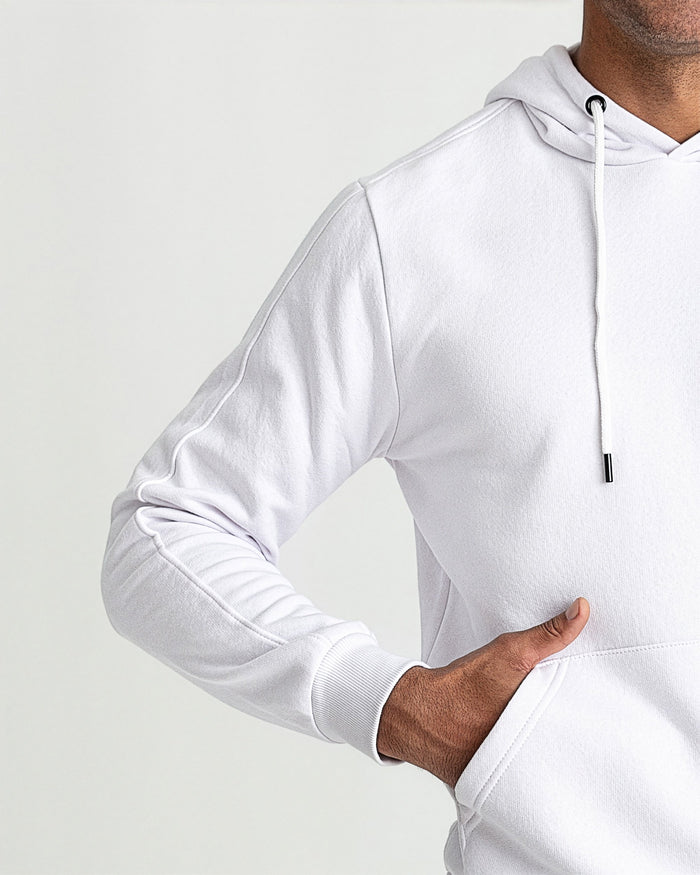 White pullover hoodie with drawstring and ribbed cuffs, shown on model from shoulder to waist.