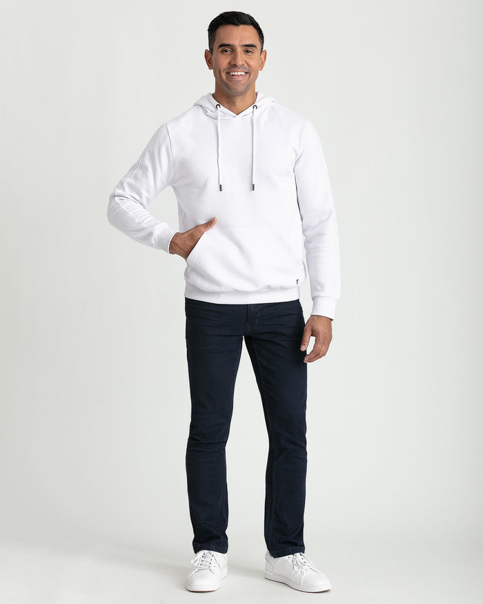 White pullover hoodie with drawstring and front kangaroo pocket, displayed on model wearing dark jeans.